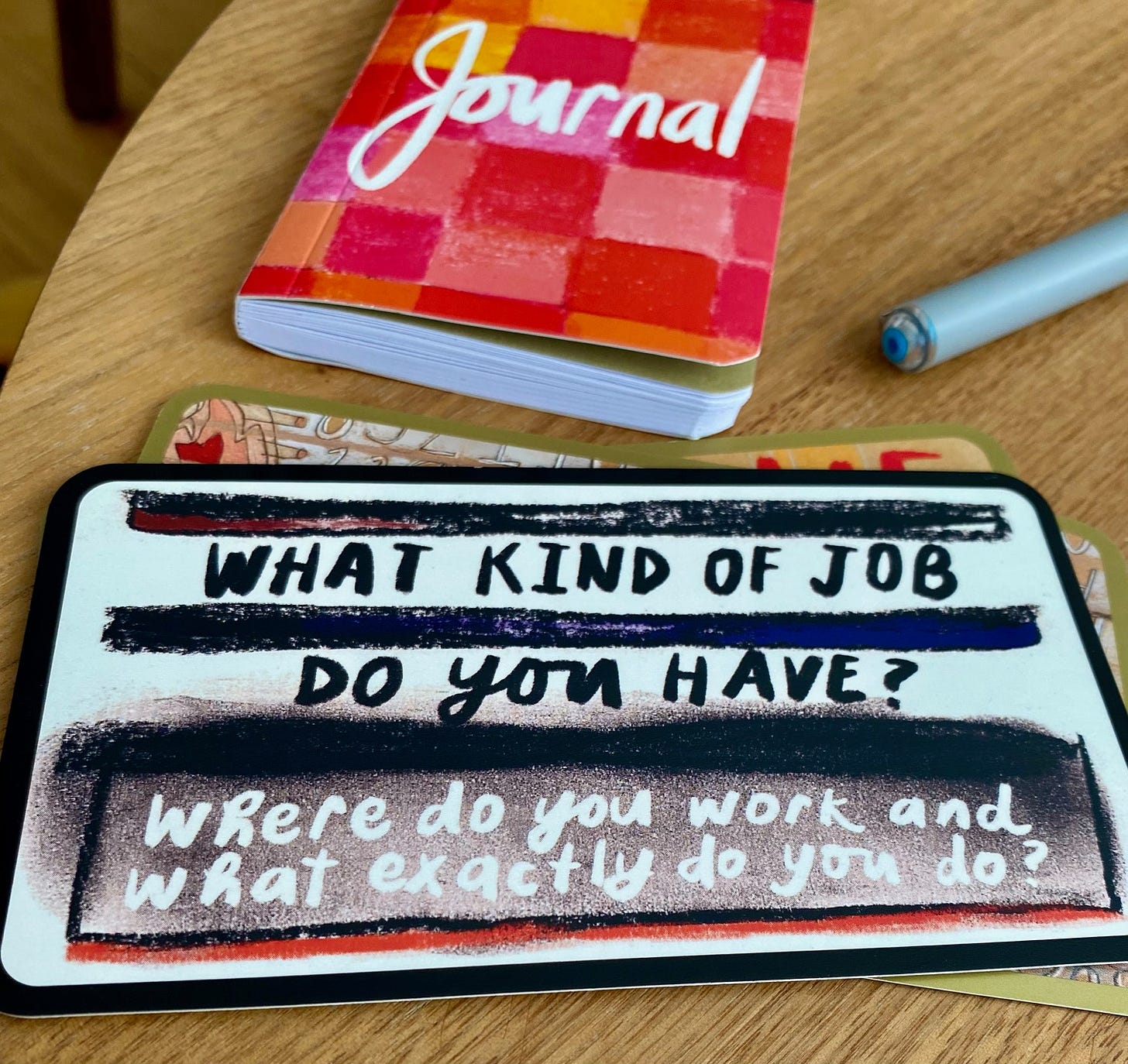 Image of card that reads: What kind of job do you have? Journal and pen in background.