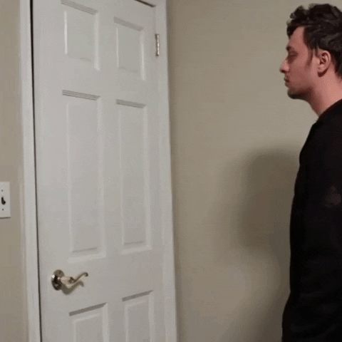 a man opens a door to reveal the same door closed immediately behind the first