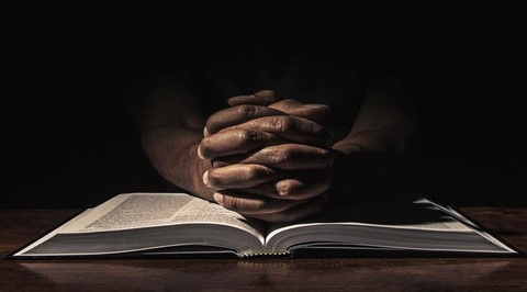 hands on Bible in prayer 