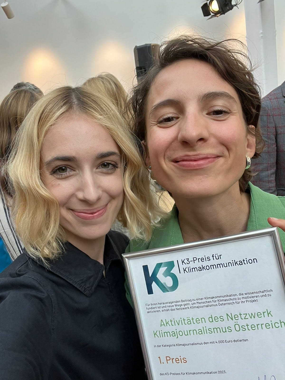Verena Mischitz und Katharina Kropshofer haben in Frankfurt den K3-Preis für Klimakommunikation entgegen genommen. Im Bild machen sie ein Selfie mit einer Urkunde des Preises.