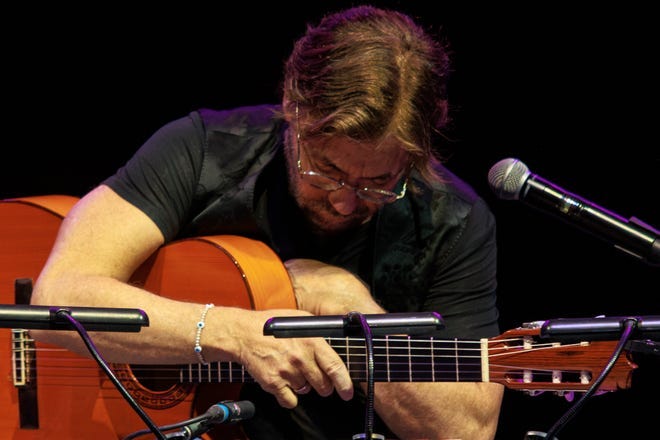 U.S. guitarist Al Di Meola clutches his chest shortly before struggling to walk off the stage at the Arenele Romane concert venue during his performance in Bucharest, Romania, Wednesday evening, Sept. 27, 2023.