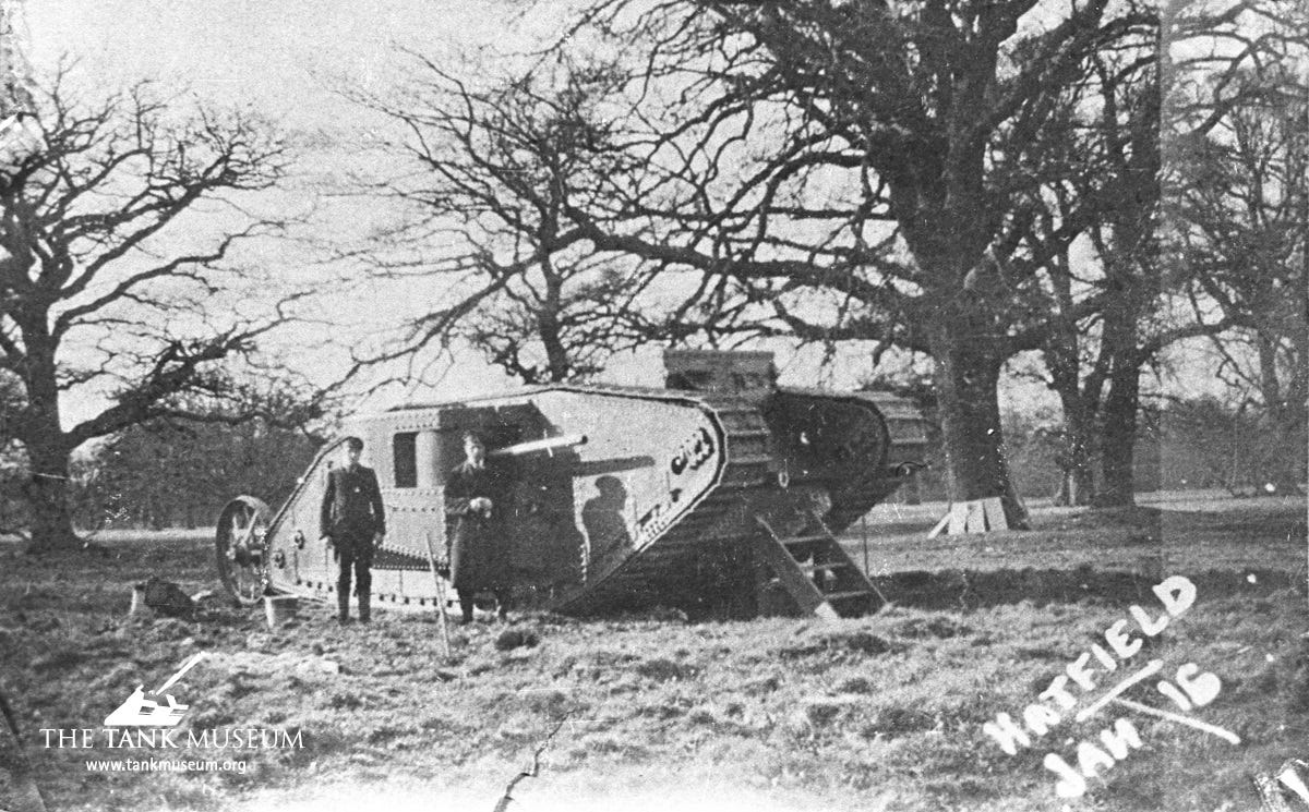 A black and white photograph of Mother tank with two men stood in front of it. The Tank Museum logo is on the left hand side and the writing 'Hatfield' is on the right hand side.