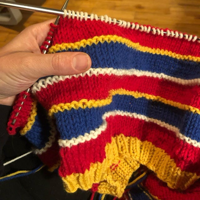 In progress sweater in blue, yellow, red, and white stripes