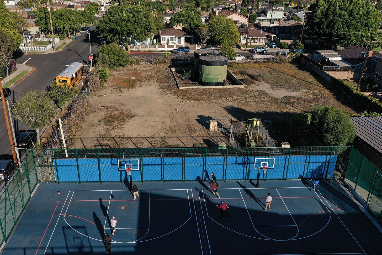 Children play basketball beside an oil well pump jack and tank in the Wilmington neighborhood of Los Angeles. Credit: Robyn Beck/AFP via Getty Images