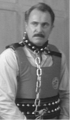 Actor Dabney Coleman as the tyrannical, sexist boss in a harness and chains