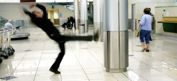 person slips on tile floor in airport baggage claim