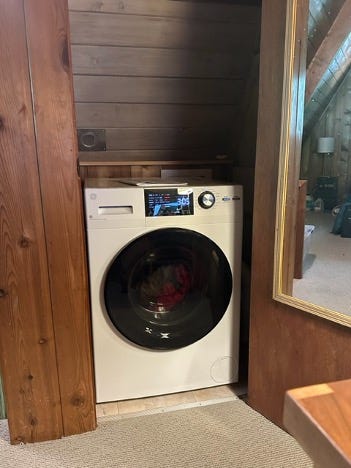 A white combination washer and dryer in a closet