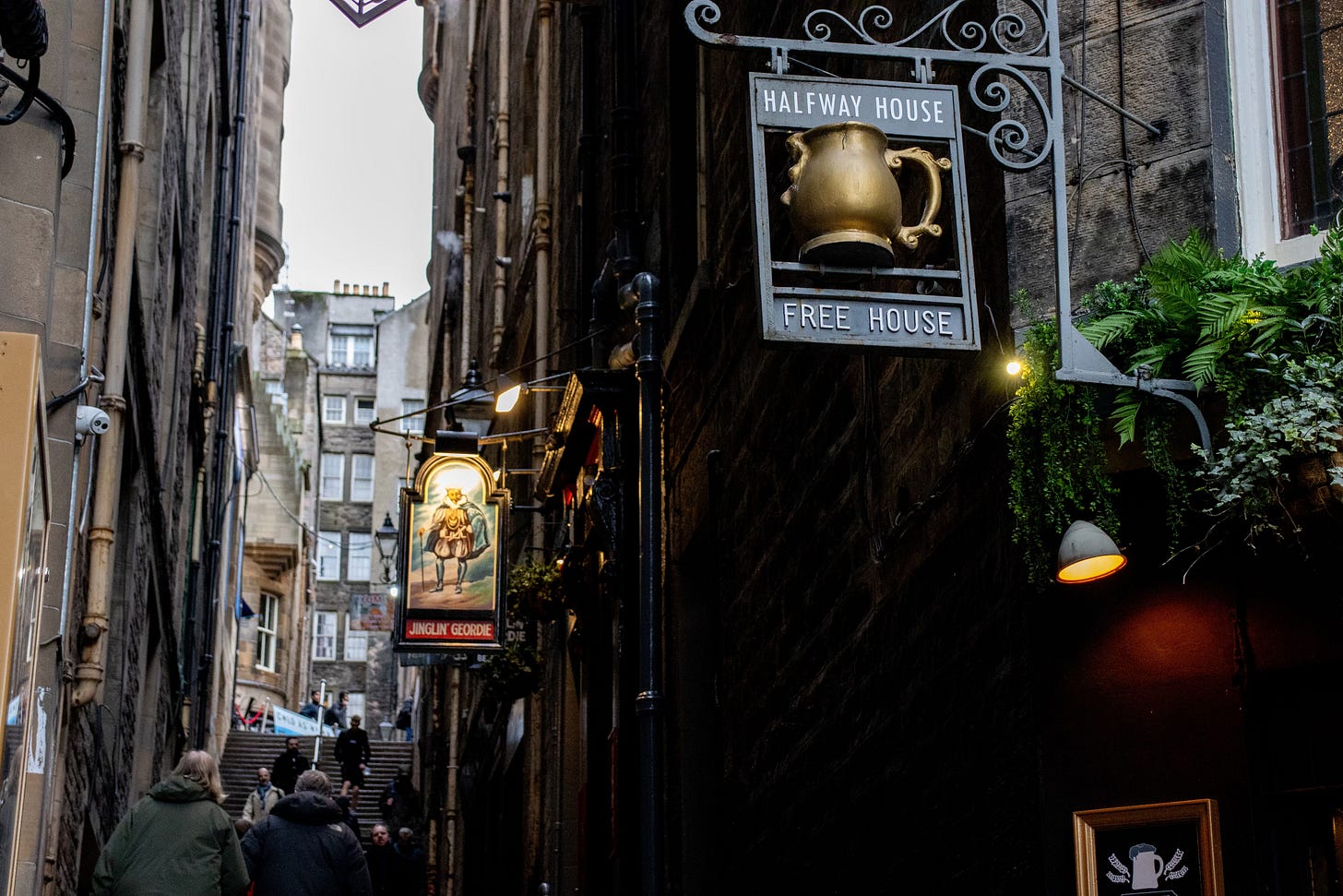 The signs of the Halfway House and Jingling Geordie, next to each other in the busy narrow alleyway of Fleshmarket Close