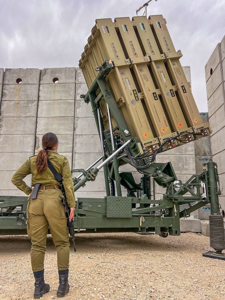 Iron Dome operator standing behind a missile launcher.