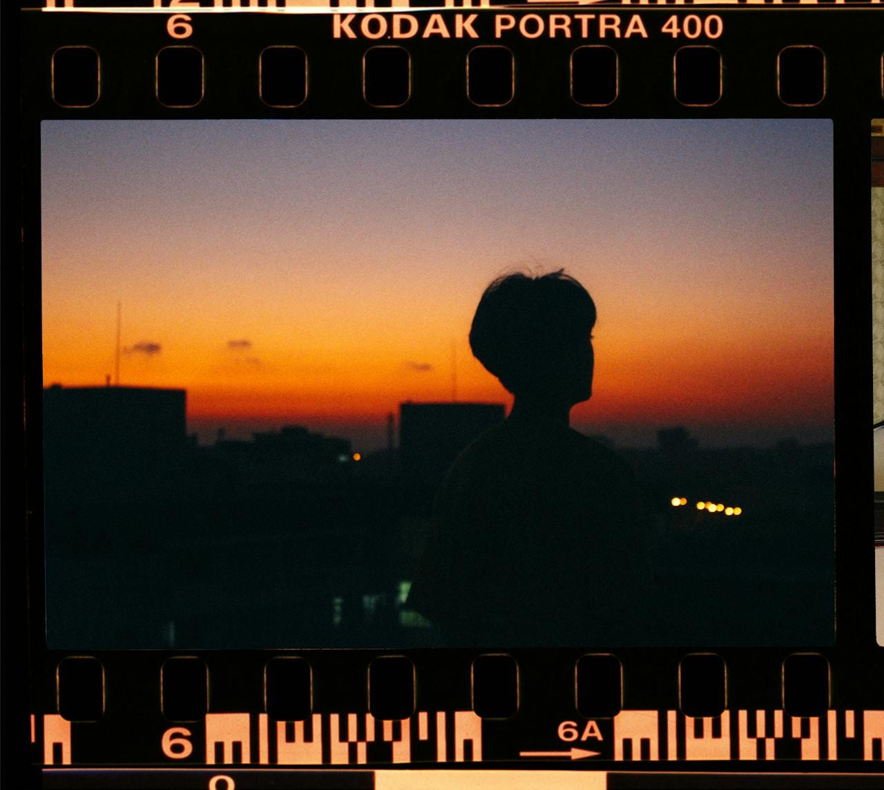 Film negative showing a person contemplating the sunset.