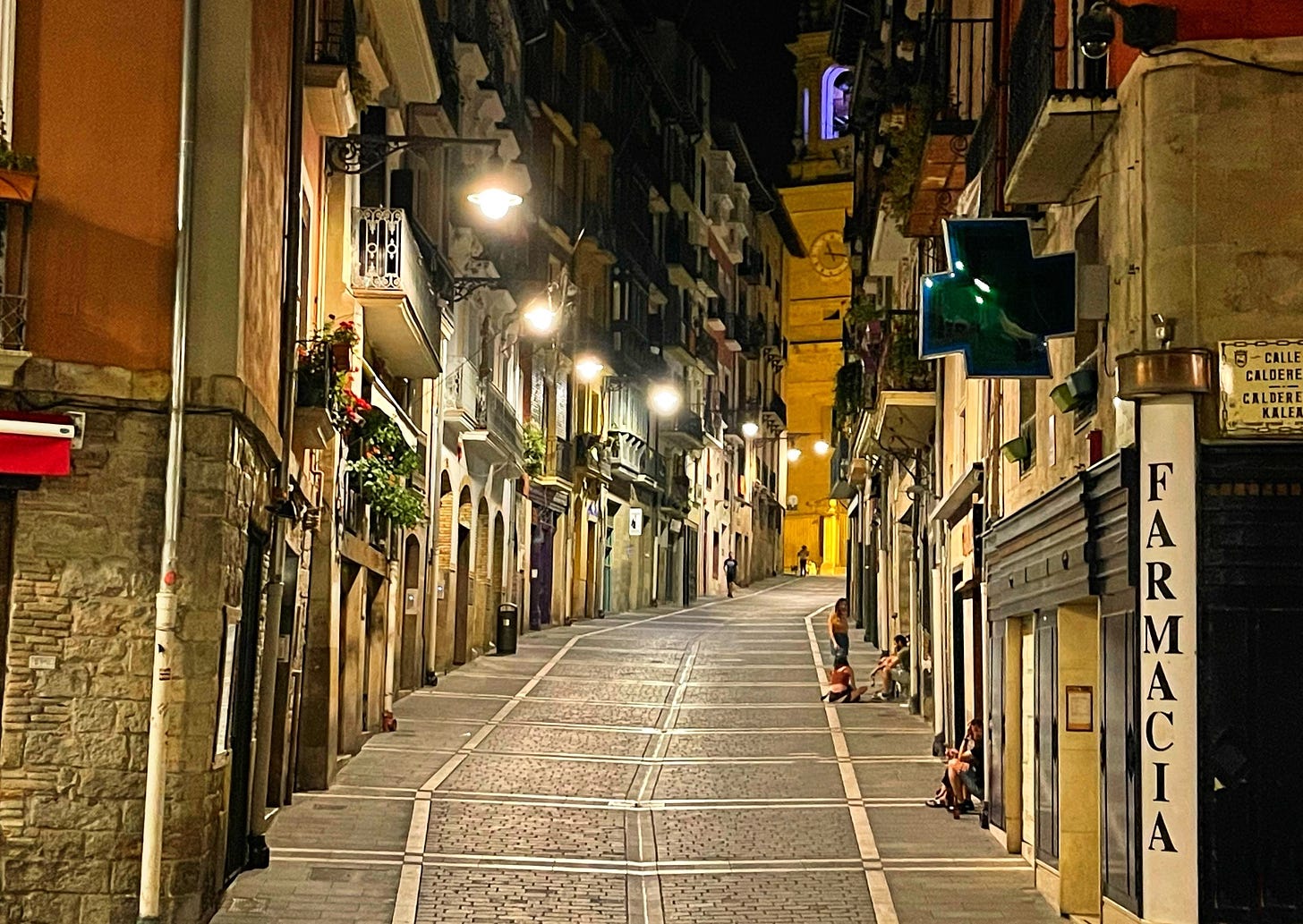 a quiet narrow street at night leading to a church