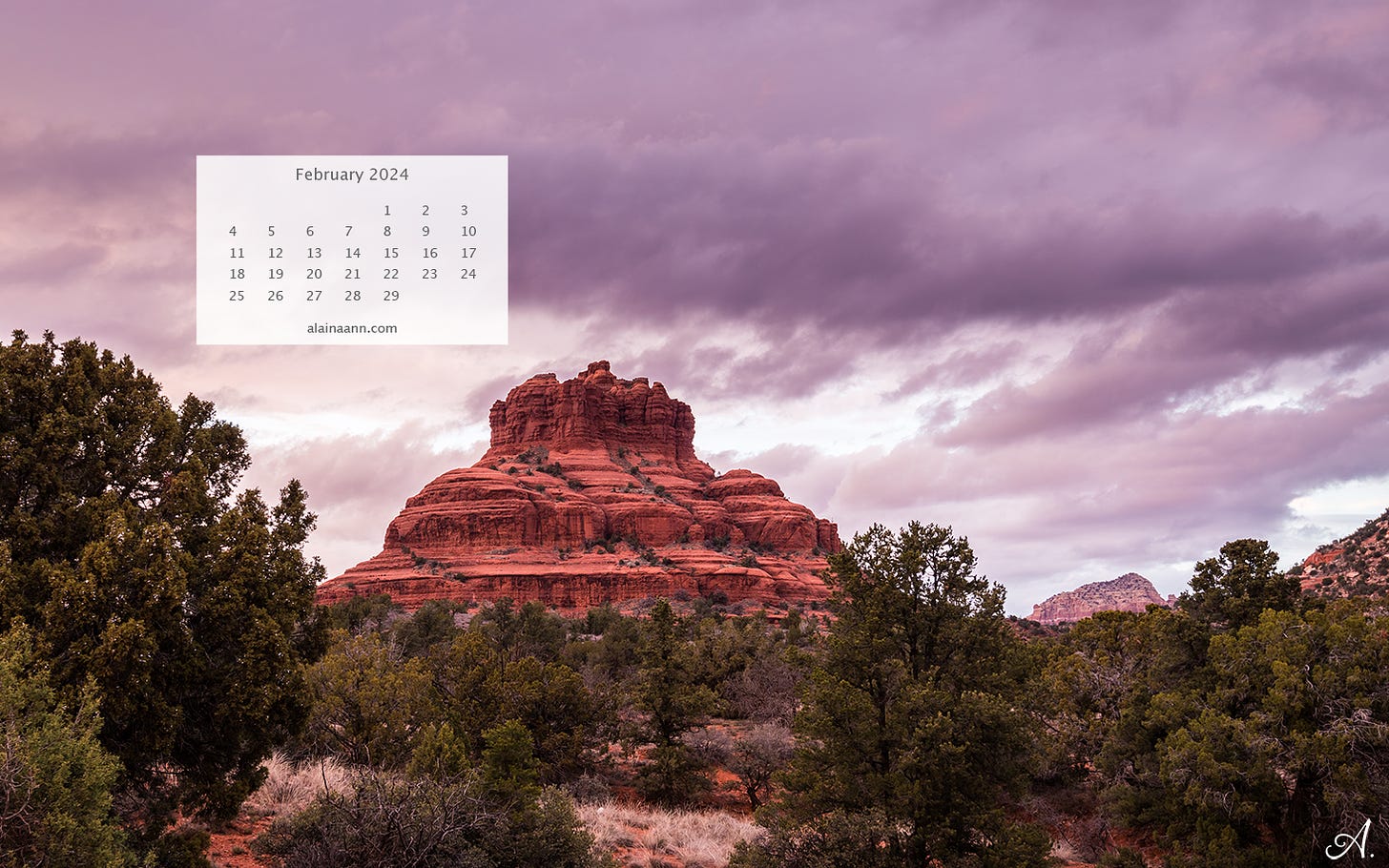 A bell shaped red rock formation, surrounded by green desert vegetation. The clouds in the sky are fluffy and purple. There's an overlaid calendar for the month of February in the upper left corner.