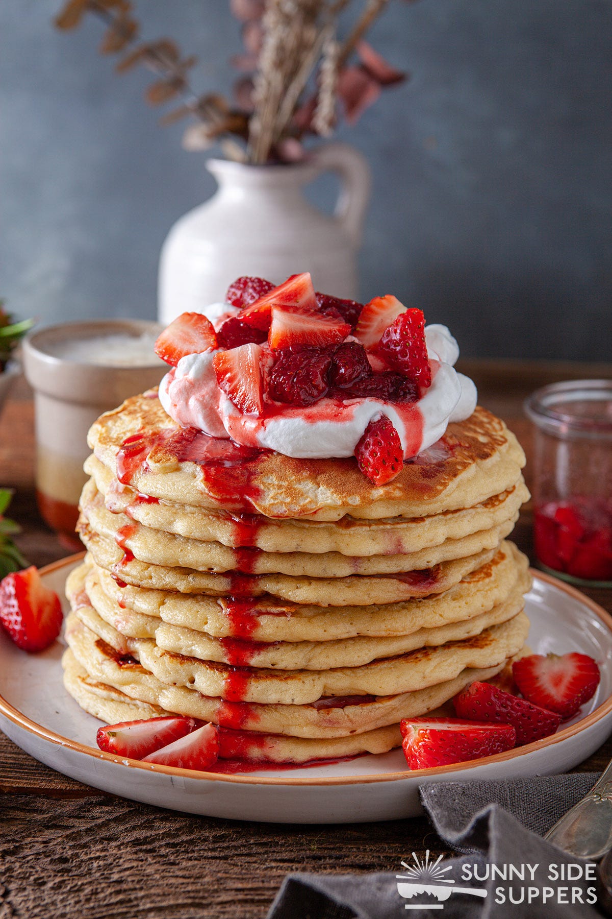 A tall stack of strawberry pancakes.