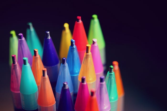 a rainbow of colored pencils on a dark background