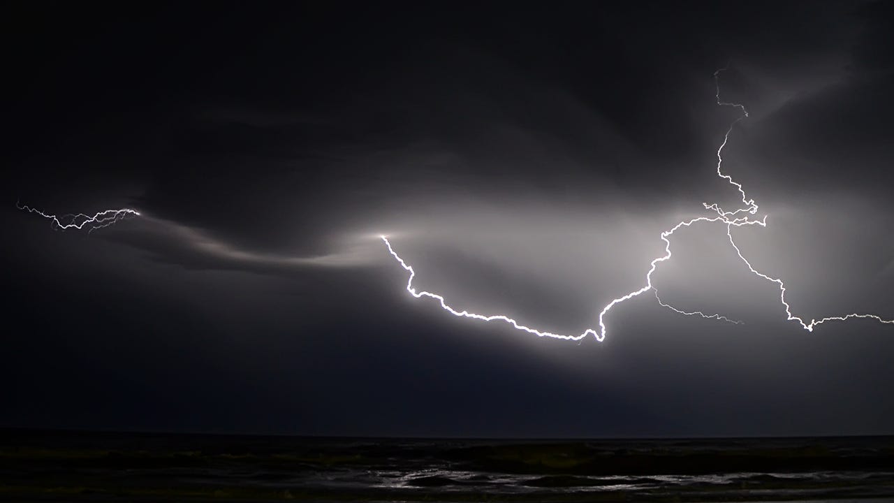 black and white image of lightning streaking against the sky