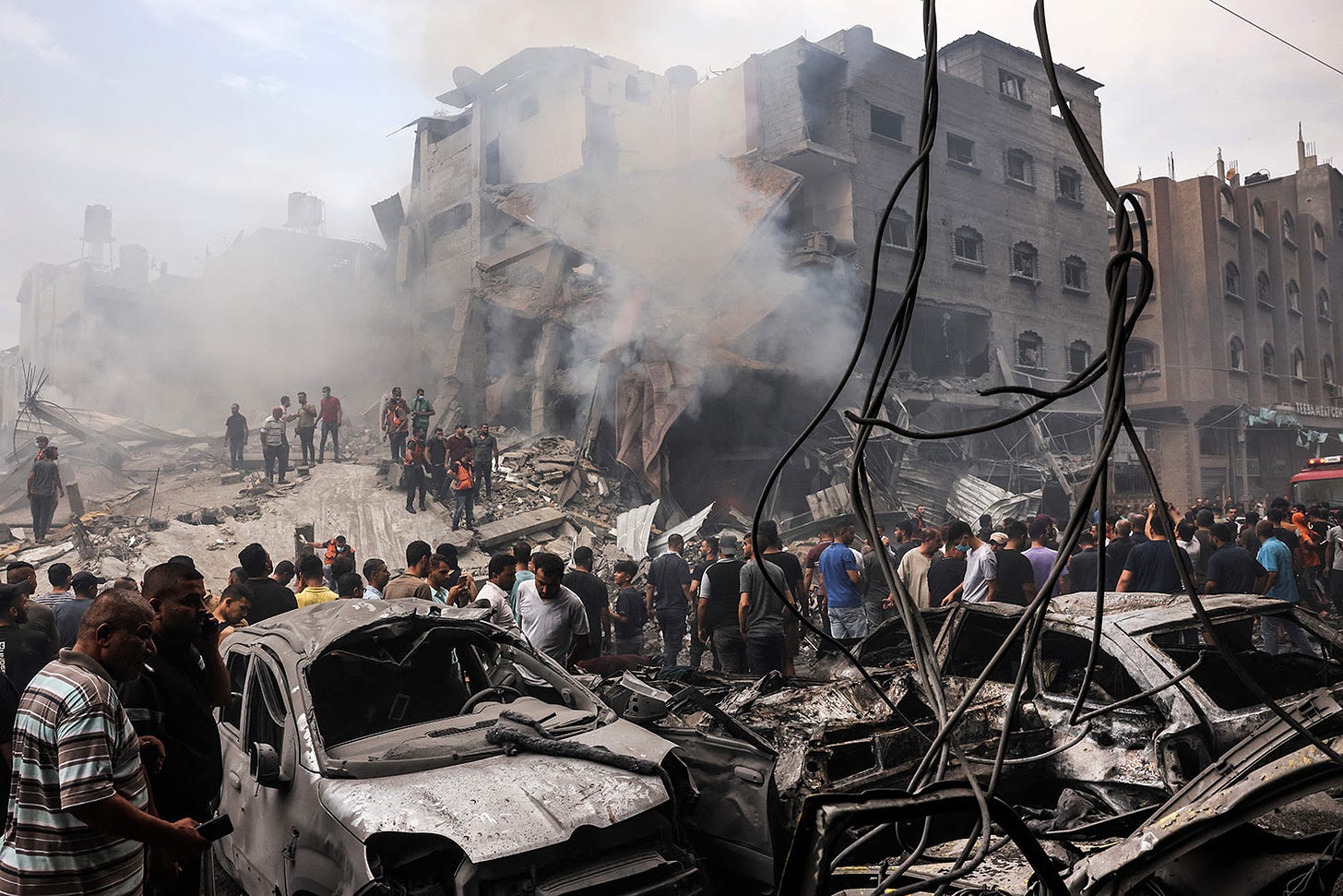 Smoke rises from damaged buildings as Palestinians search for survivors in the Gaza Strip.