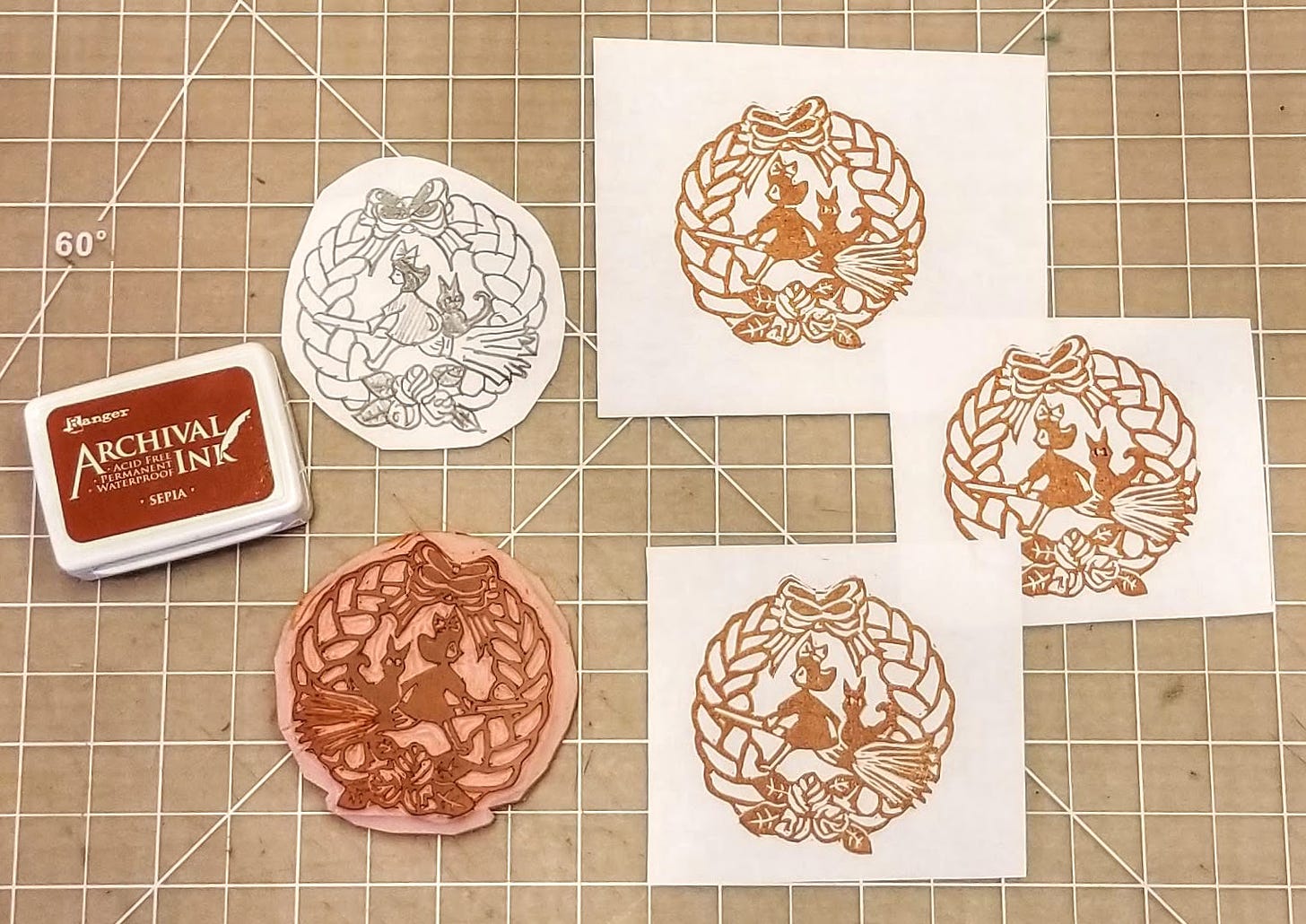 haand-carved stamp of the bakery sign from Kiki's Delivery Service next to an ink pad and three small prints