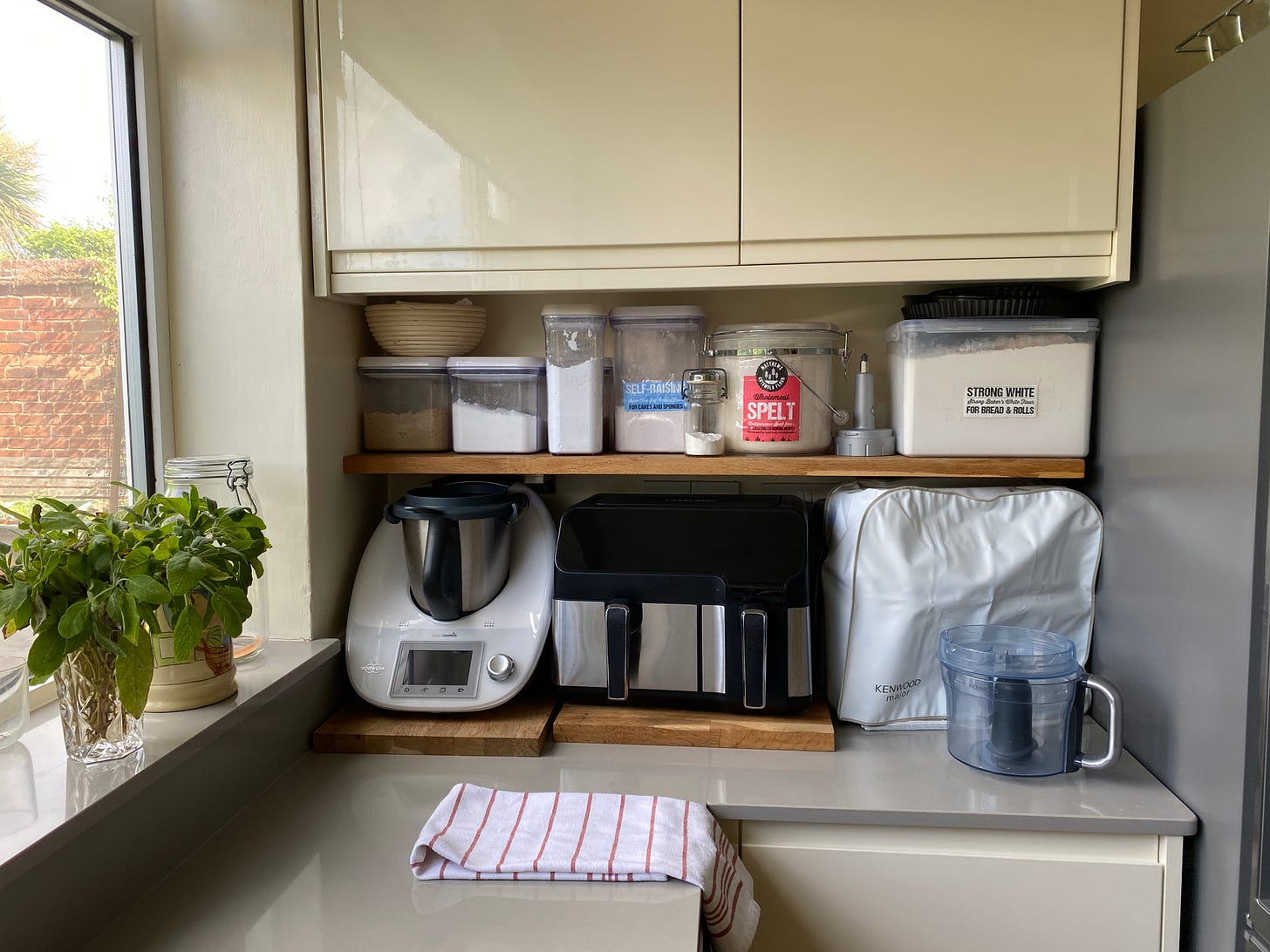 Shelves and cupboards with containers and kitchen appliences.