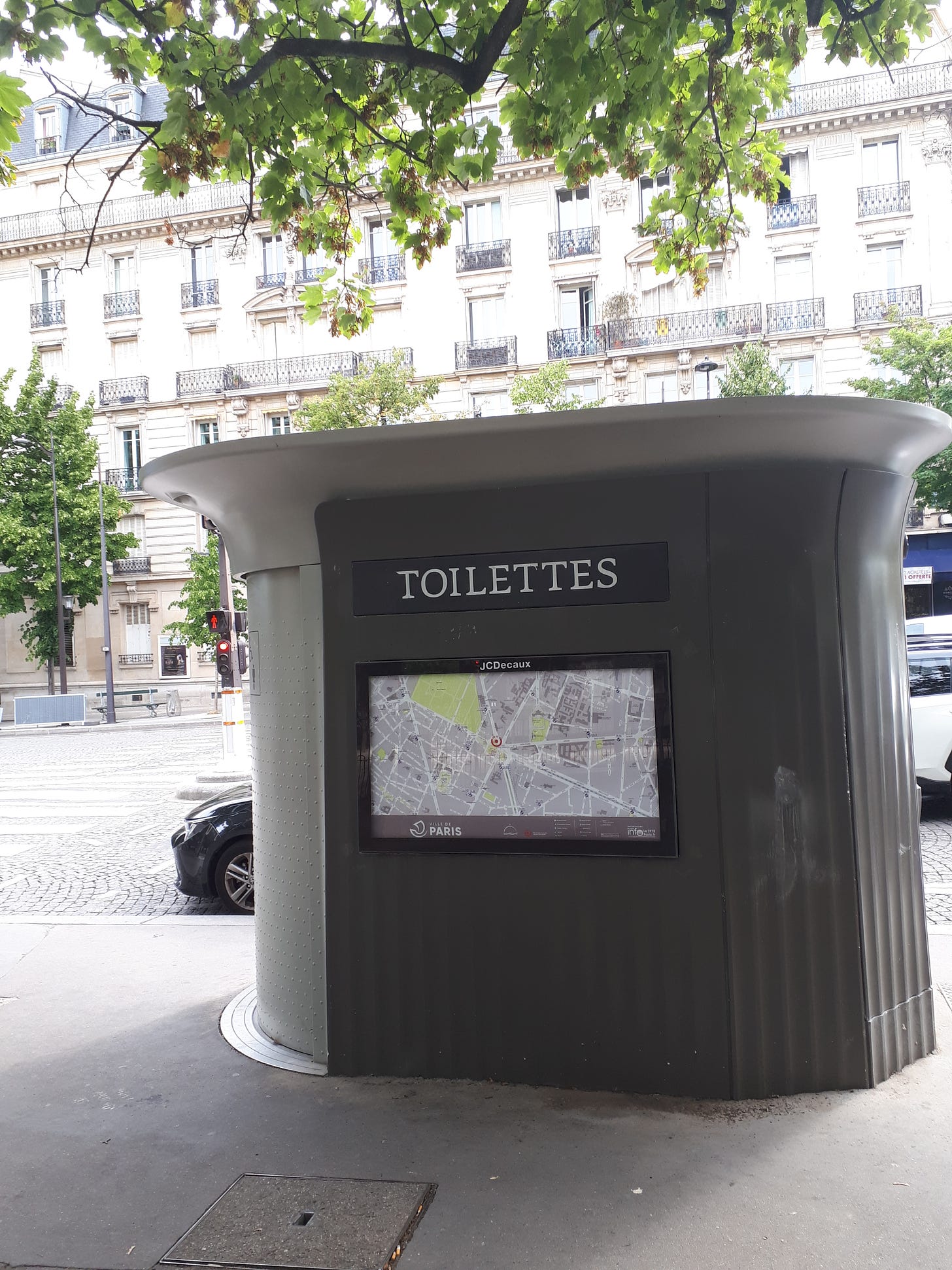 Large oval 'kiosk' housing a public washroom on a Paris street.