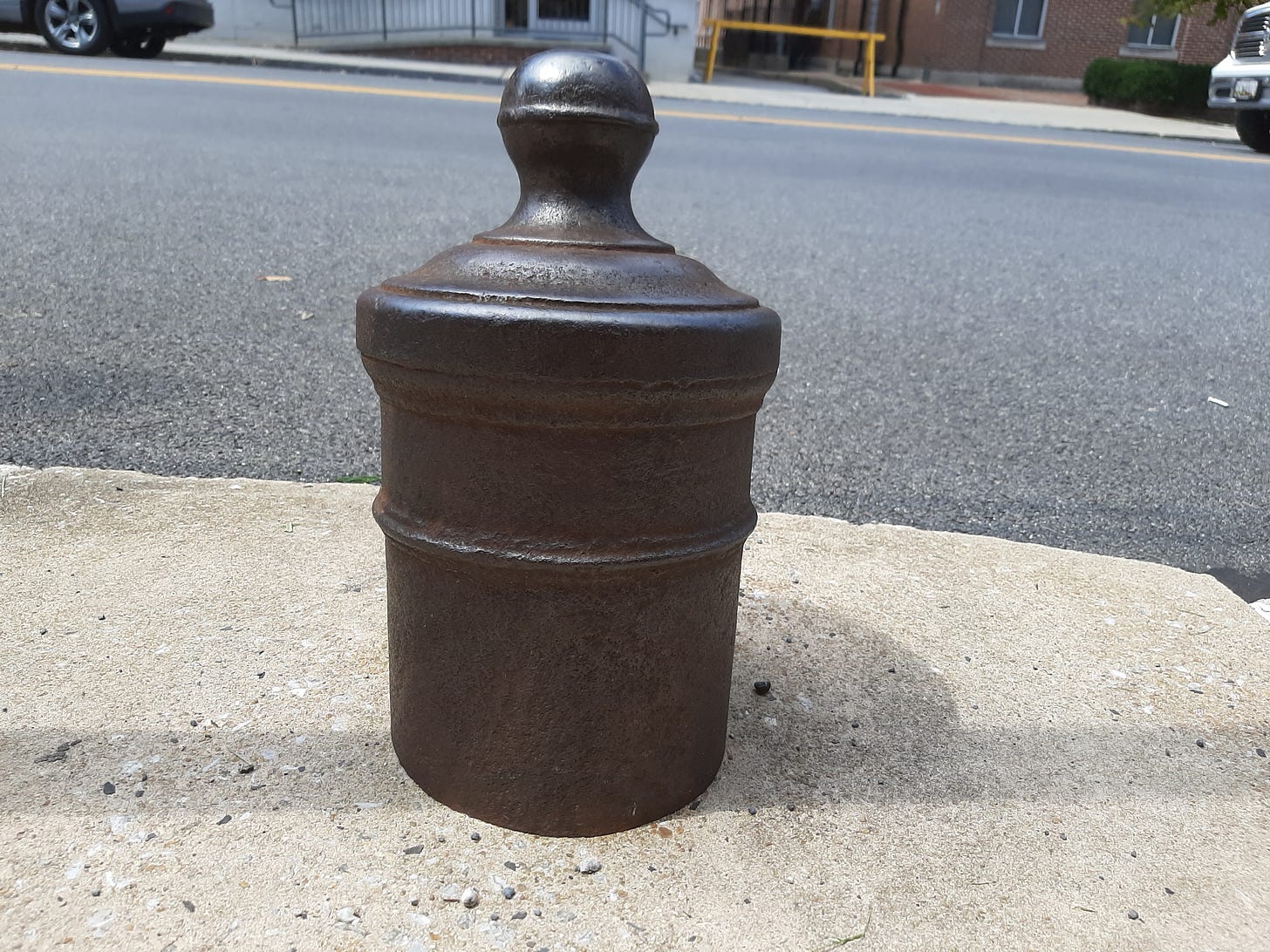 top of cannon sticking out of sidewalk.