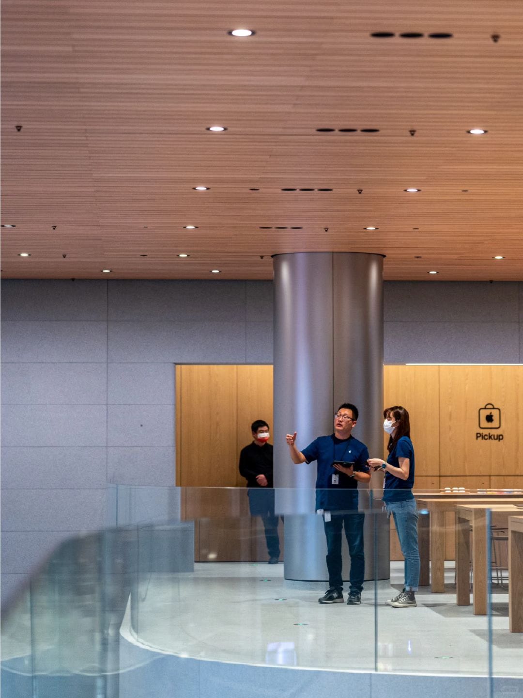 Two Apple employees chat near the Apple Pickup counter on the upper level of Apple Jing'an.