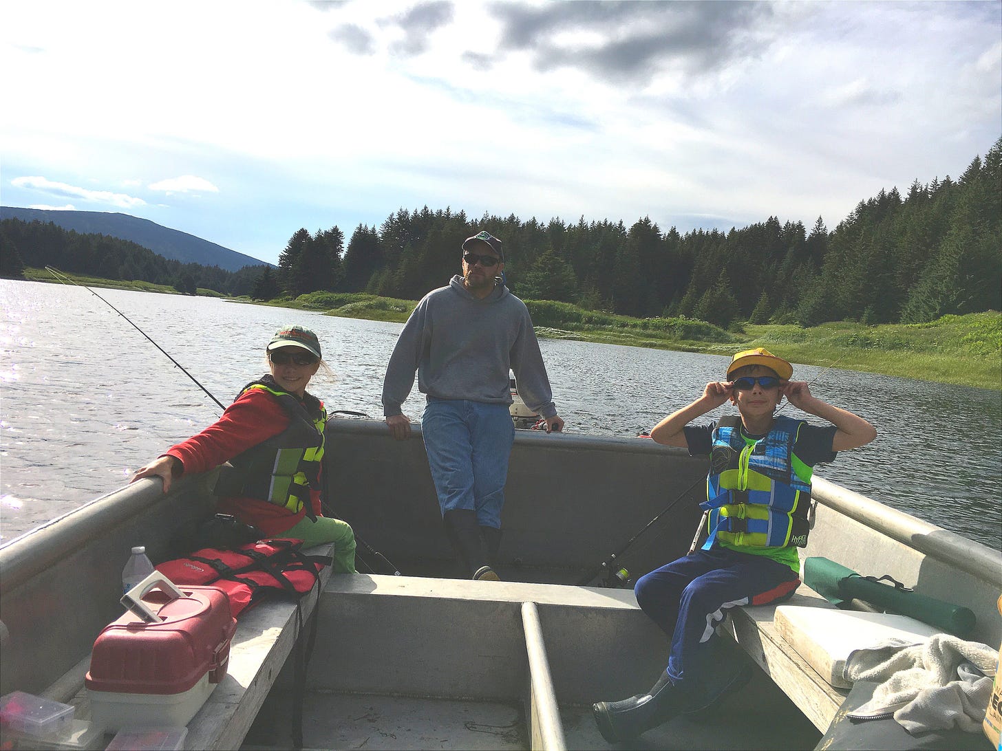 Jesse McEntee and his children on a motored skiff, navigating up river to go fishing.