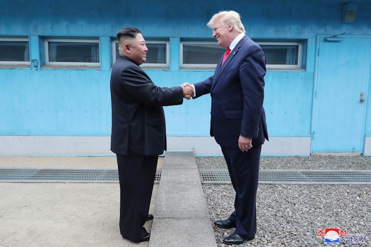 Donald Trump shaking hands with Kim Jong-un Donald Trump shaking hands with Kim Jong-un