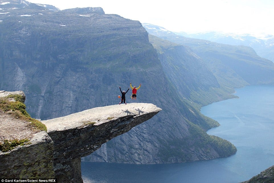 Thrill-seekers jump on Trolltunga clifftop 2,300ft above Norwegian ...