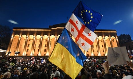 Protesters wave Georgian, Ukrainian and EU flags outside parliament in Tbilisi