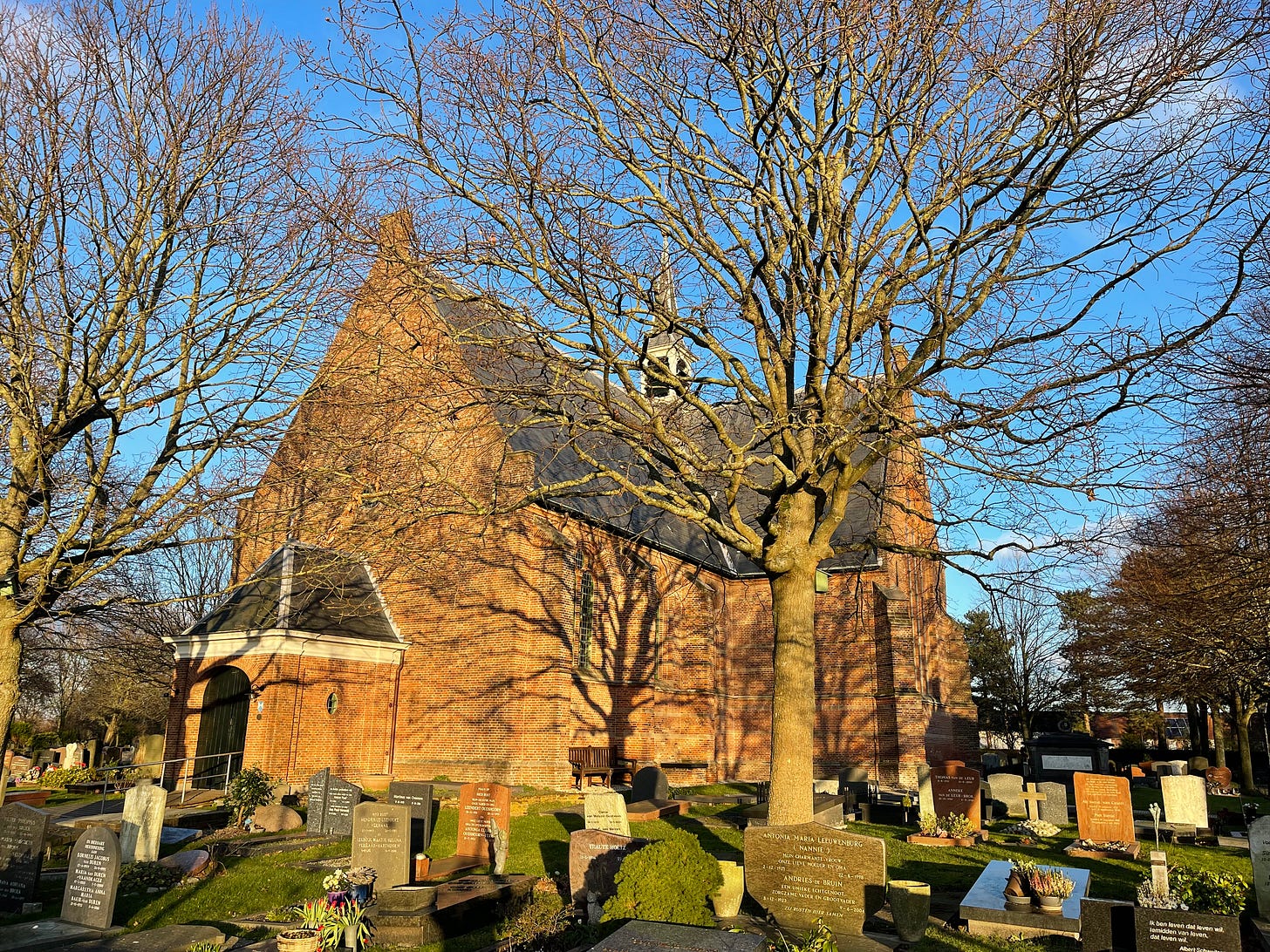 small church in evening light, surrounded by trees and tombstones. I grew up close to this church