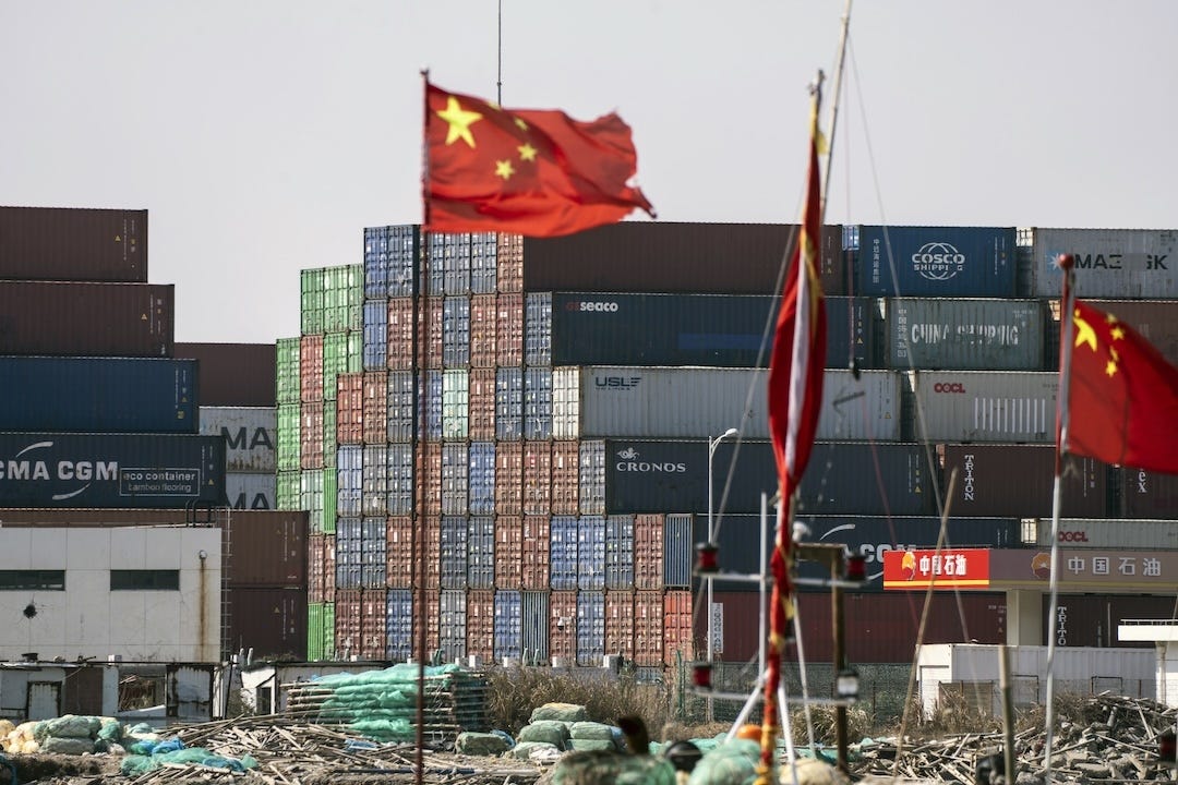 Chinese flags fly in front of shipping containers at the Yangshan Deepwater Port in Shanghai. Photo: Bloomberg