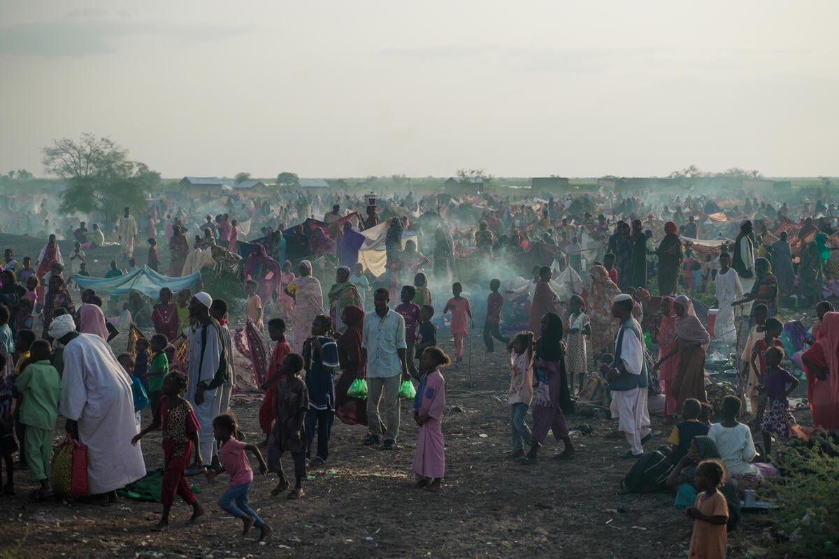 A large number of new arrivals from Sudan wait in a field in South Sudan