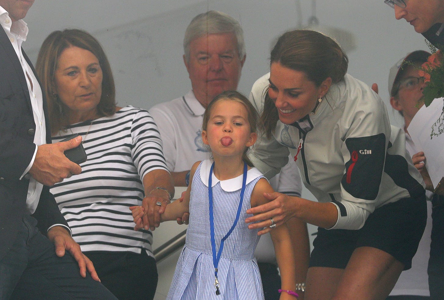 princess charlotte sticking out her tongue with mum kate and grandmother carole middleton