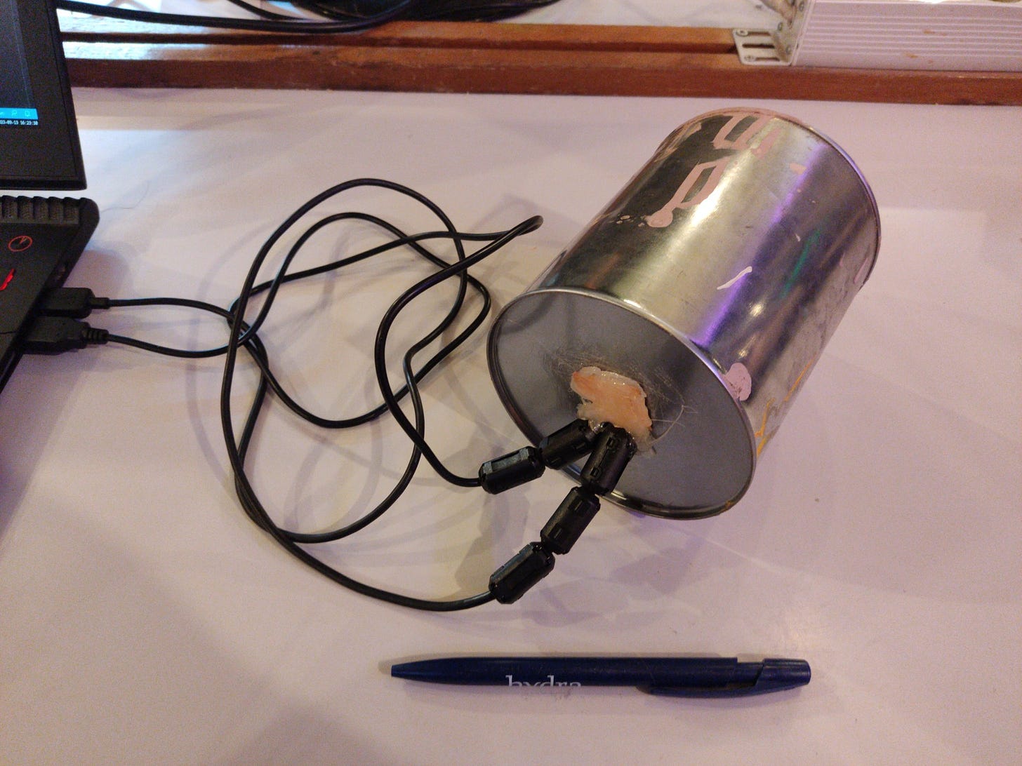 Faraday cage made from a paint tin, with copper tape to close the hole for the USB connectors, and ferrite chokes to reduce the RF leaking in