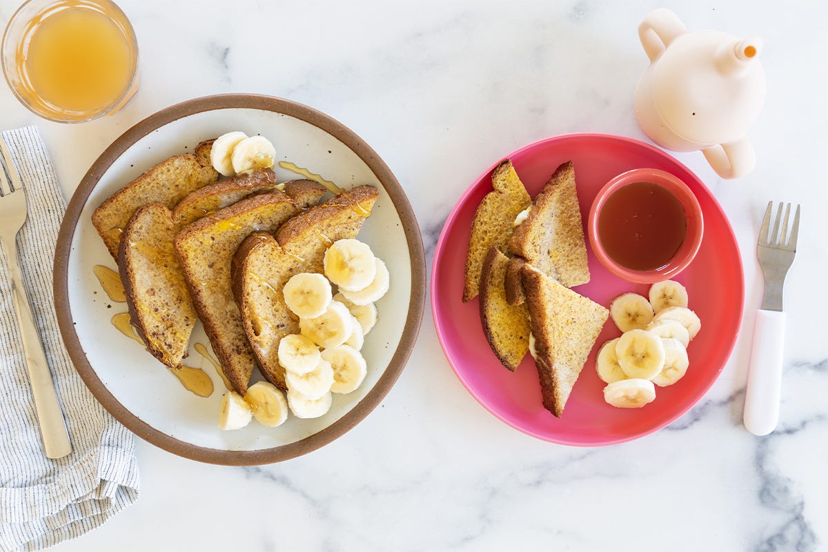 French toast on two plates with sides. 