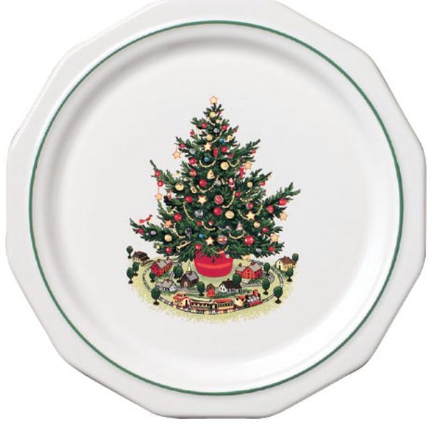 A photo of a classic Pfaltzgraff “Christmas Heritage” dish pattern featuring a decorated Christmas tree in the center with a white stone background.