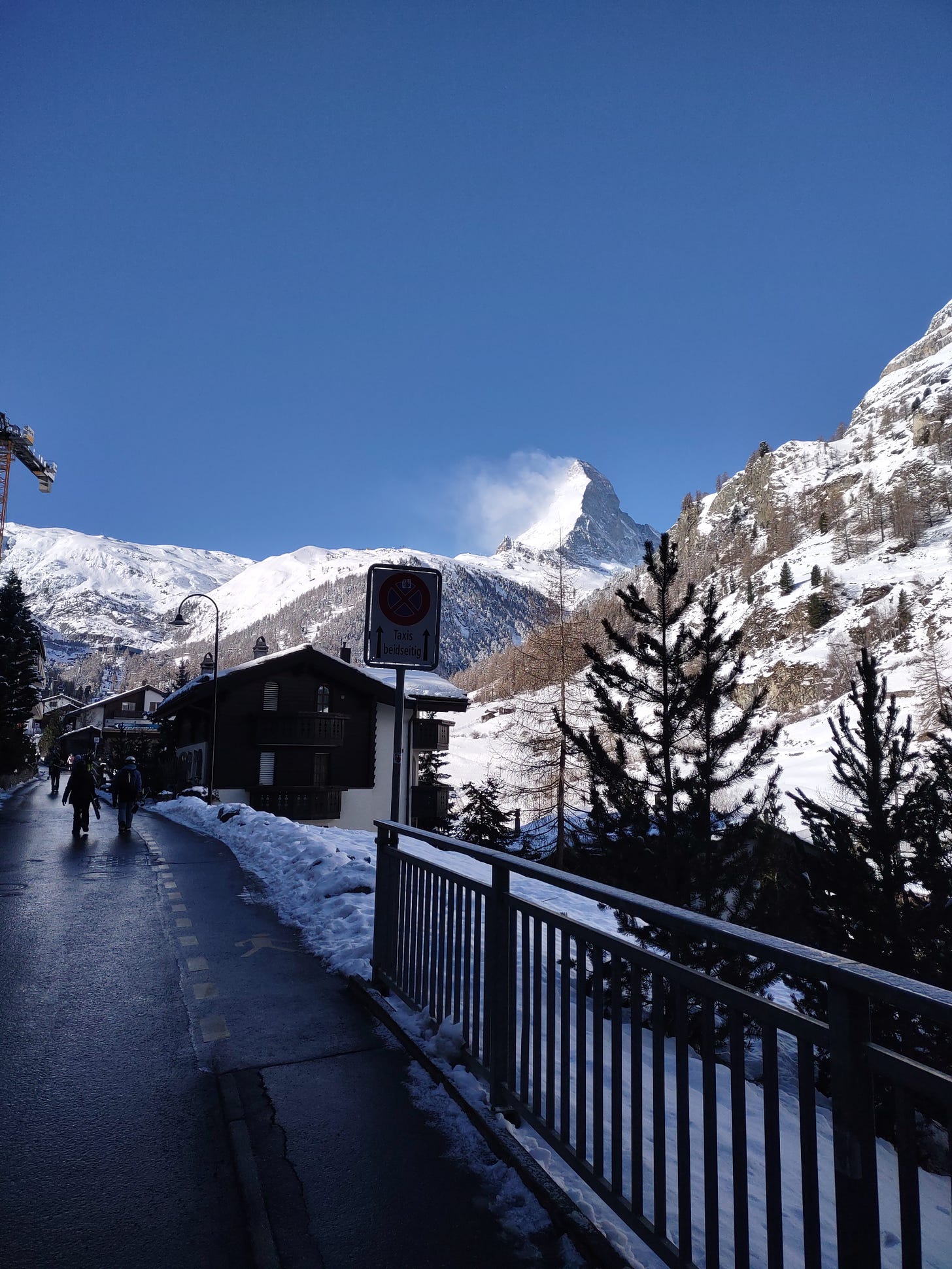 Picture of the matterhorn from Zermatt village. The wind is blowing snow off the left side and the sku is blue.