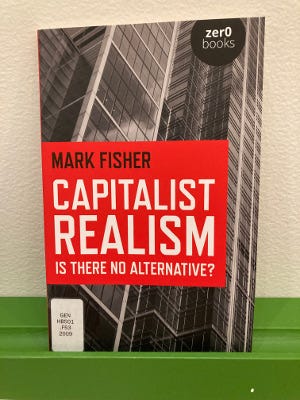 A copy of Mark Fisher Capitalist Realism: Is There No Alternative? sitting on a shelf