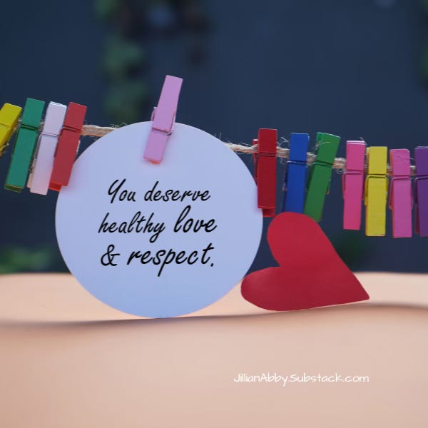 A twine clothes line with multi-colored clothes pins. One pin is holding a white paper circle that says "You deserve healthy love & respect."