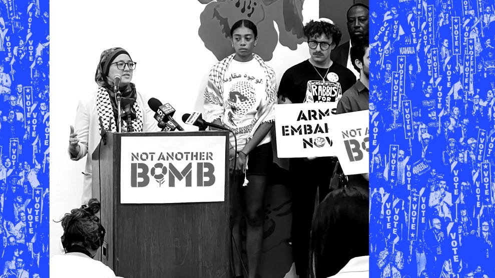 Black and white photo of Georgia Representative Romman speaking to a group of reporters and supporters behind a podium bearing the slogan "Not Another Bomb."