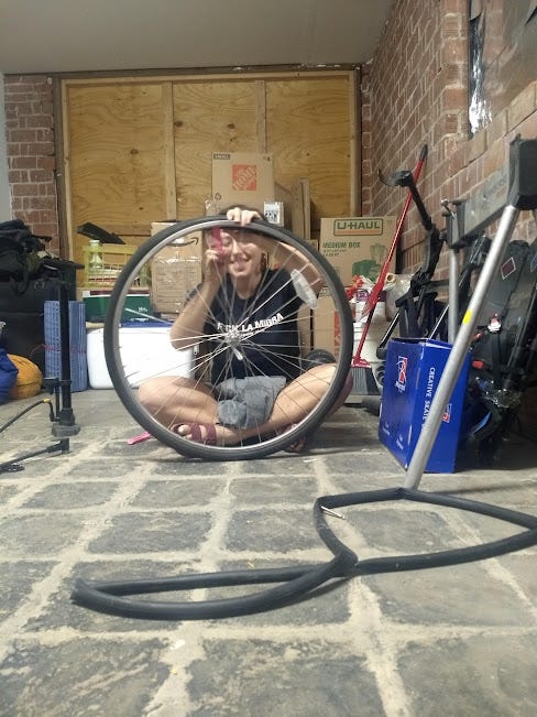 a cute person is replacing a bike tube on a bike wheel