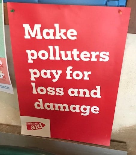 Red poster with white text: Make polluters pay for loss and damage