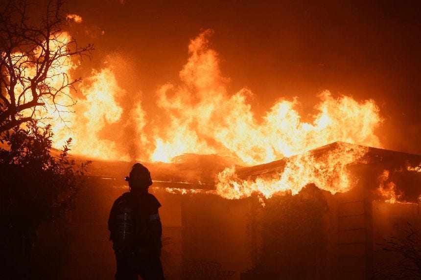 A firefighter works to extinguish flames as the Eaton Fire burns in Pasadena, California, U.S. January 8, 2025. REUTERS/Mario Anzuoni