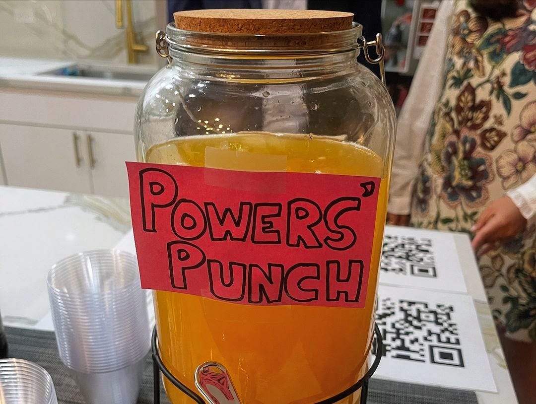 A pitcher of orange cocktail with a label saying "Powers Punch"