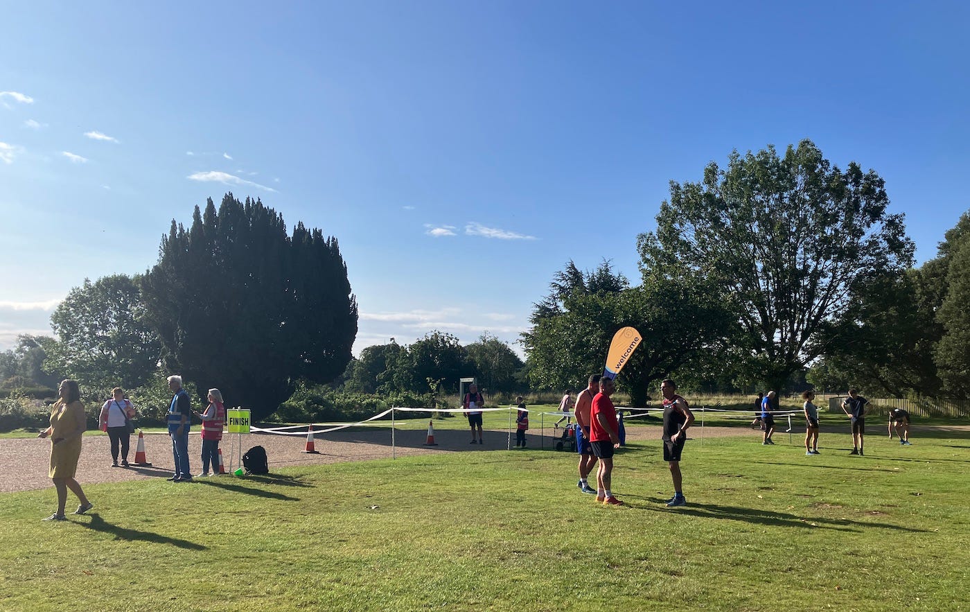 Blue sky above the finish funnel, which leads from the gravelled path to grass