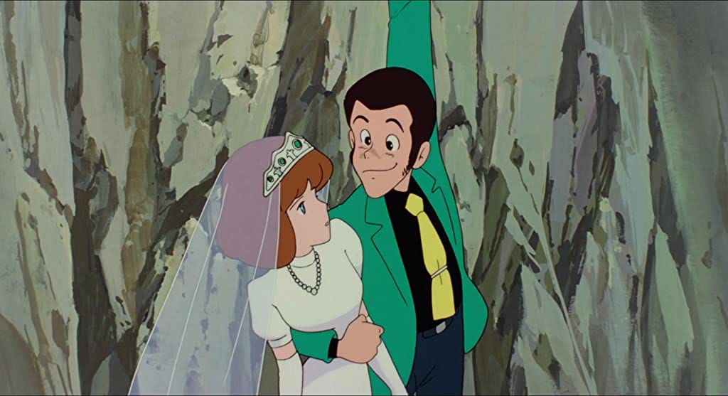 Lupin e Clarisse (la donna vestita da sposa) sospesi in aria con alle spalle il dirupo. Lupin si sta reggendo a qualcosa fuori campo con la mano sinistra e con la destra regge Clarisse.