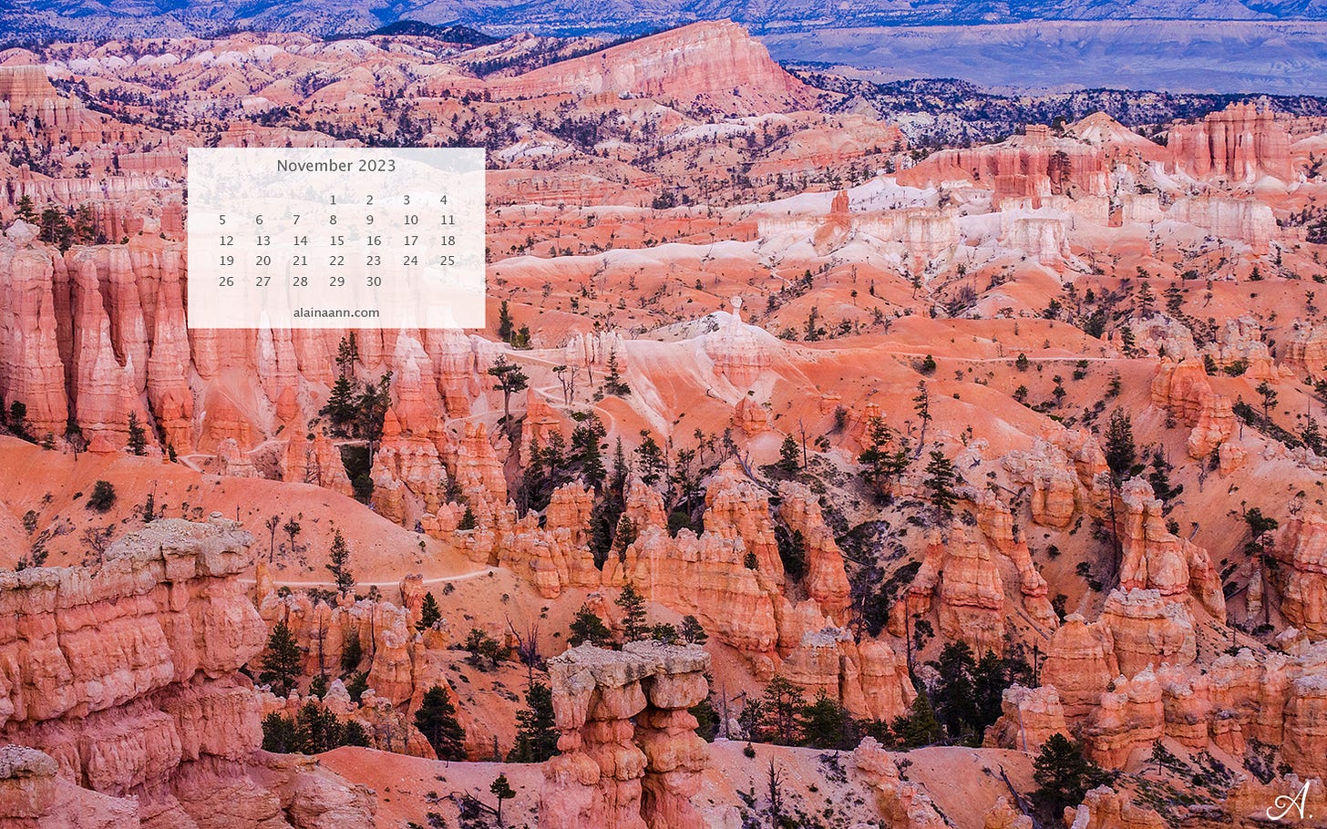 Landscape of orange and white hoodoos with a thin white trail curving between the rock formations. A calendar for the month of November is in the upper left corner.