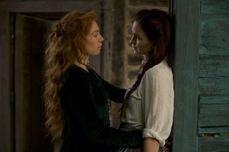 Tallie e Abigail se olham. ambas estão de lao para a câmera
