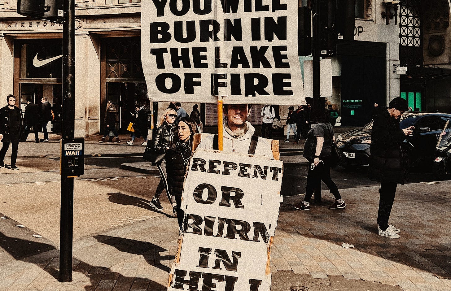 Man holding sign that says to repent or burn in hell.