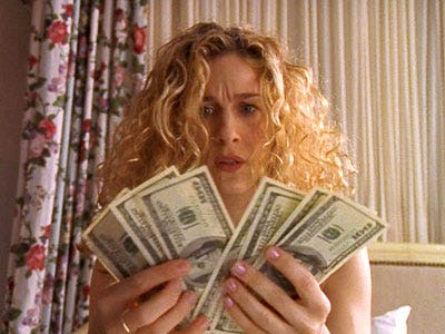 Carrie holding a handful of $100 bills in Sex and the City